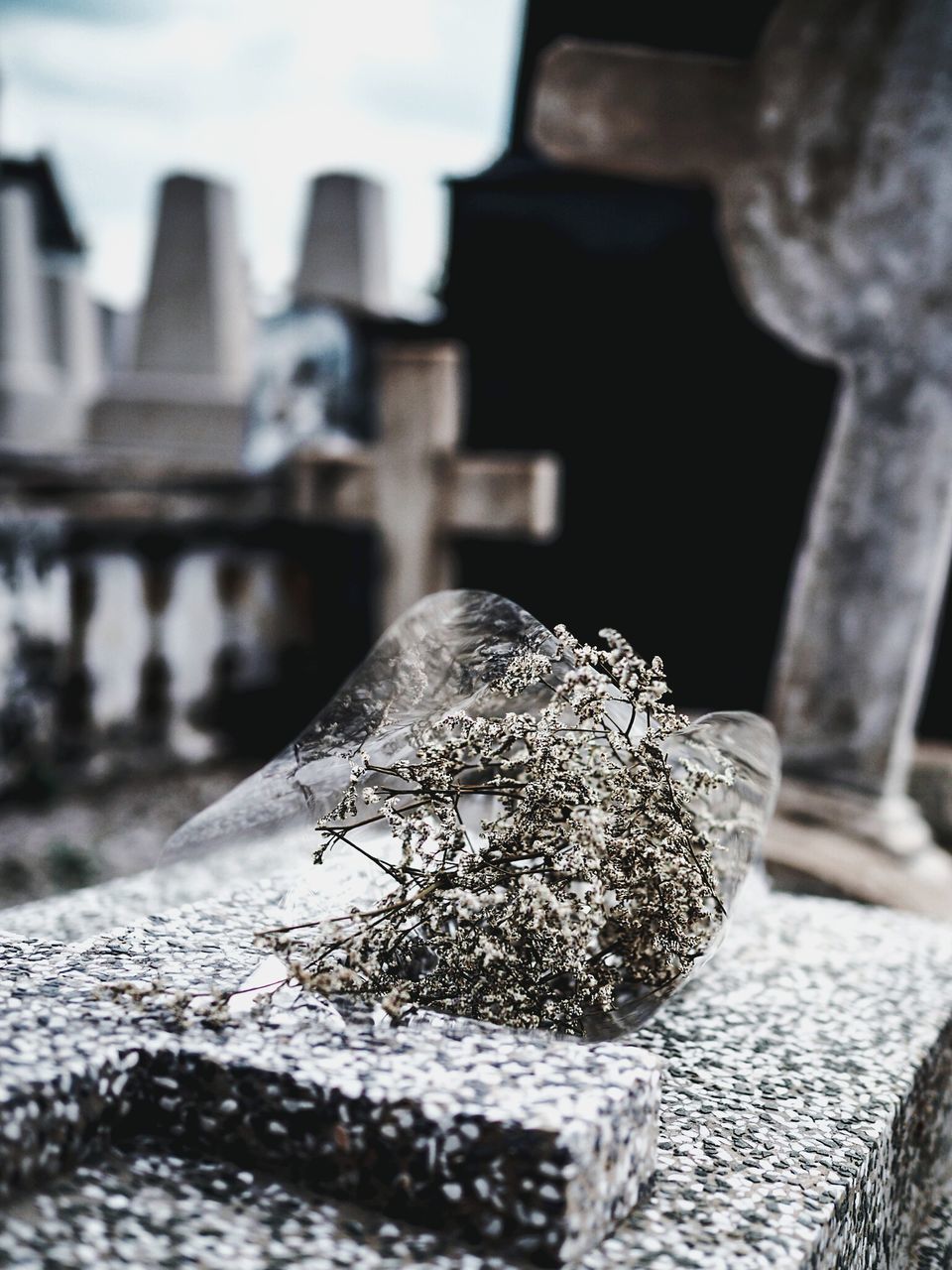 CLOSE-UP OF CROSS ON TABLE AGAINST BUILDINGS