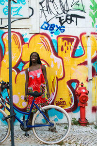 Full length of boy standing on bicycle in city