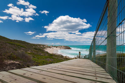 Wooden walkway leading to indian ocean beach, de hoop nature reserve, south africa against sky
