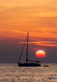 Silhouette sailboat on sea against sky during sunset