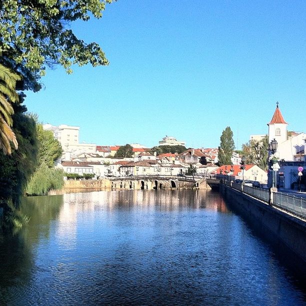 architecture, building exterior, built structure, water, clear sky, blue, waterfront, house, tree, river, copy space, residential structure, residential building, town, residential district, canal, city, day, outdoors, sky