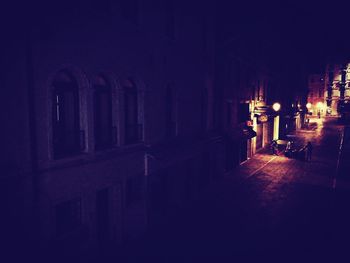 Narrow footpath along illuminated buildings at night