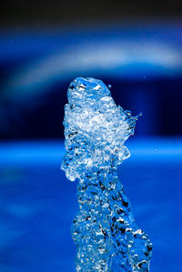 Close-up of water drop against blue sea