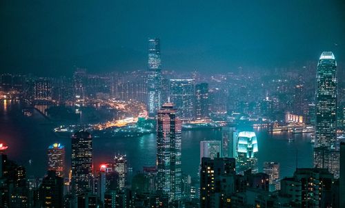 Illuminated buildings in city against sky at night