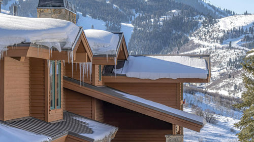 Built structure on snow covered houses against mountains