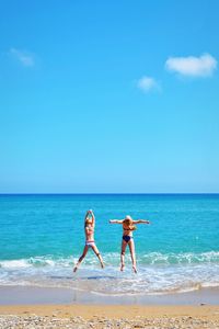 Full length of young woman at beach against sky