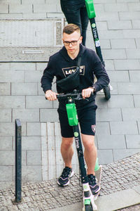 Full length of man holding umbrella on footpath