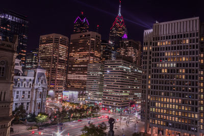 Illuminated cityscape against sky at night