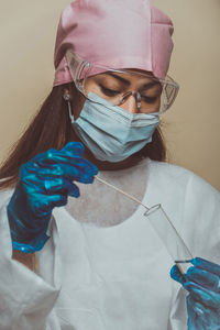 Doctor wearing mask against blue background