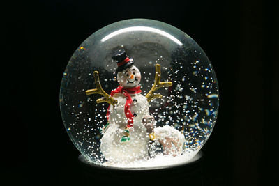 Close-up of snow globe against black background