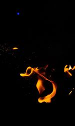 Close-up of illuminated bonfire against black background