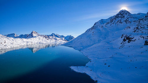 Scenic view of snowcapped mountains against blue sky