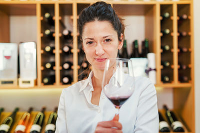 Portrait of woman holding wineglass at home