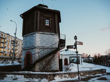 Low angle view of snow covered buildings against sky