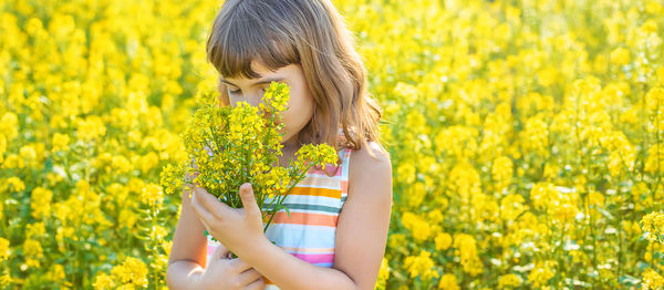 Girl smelling flowers in field