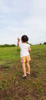 Rear view of woman standing on field