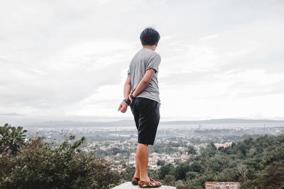 Rear view of people standing on cliff
