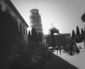 Tourists on city street against sky