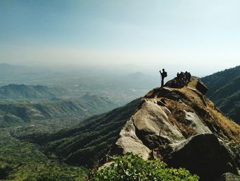 View of people on mountain peak against sky