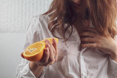 Midsection of woman holding oranges