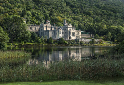 Scenic view of lake by house and trees