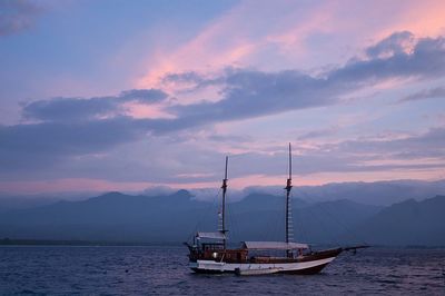 Boat moored on sea against sky during sunset