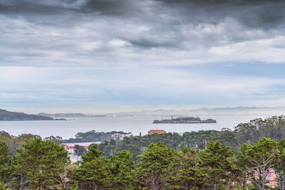 Boats in sea against cloudy sky