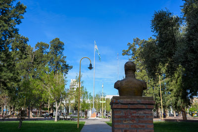 Statue in park against blue sky