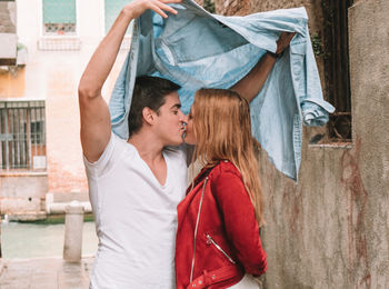 Midsection of couple standing in front of traditional clothing