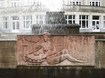 Close-up of statue against buildings in city