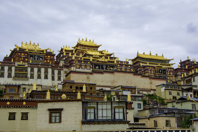 Exterior of ganden sumtseling monastery against sky