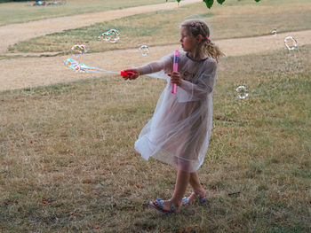 Full length of woman with bubbles on field