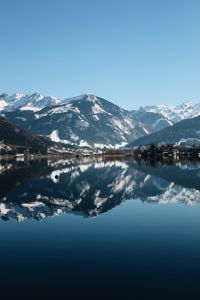 Scenic view of alpine lake and snowcapped mountains against sky