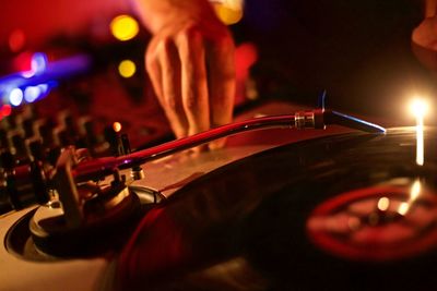 Cropped image of dj playing music at turntable