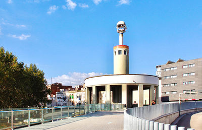 Street amidst buildings against blue sky