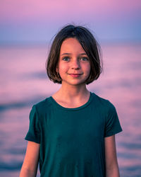 Portrait of smiling young woman standing against sky during sunset