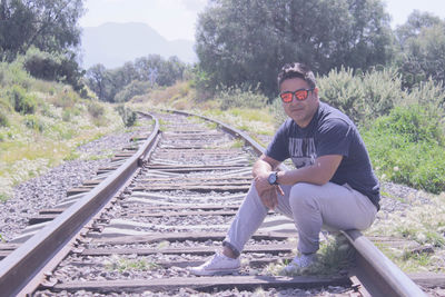 Man sitting on railroad track