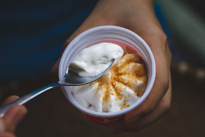 Cropped image of man holding ice cream in cup