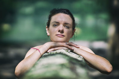 Portrait of young woman leaning on retaining wall