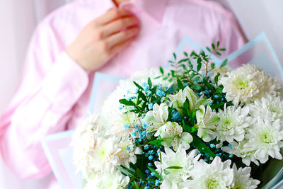 Midsection of bride holding bouquet