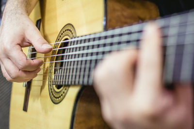 Cropped image of man playing acoustic guitar