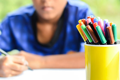 Close-up portrait of woman holding pencils