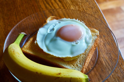 High angle view of bananas and a toast with a egg on table
