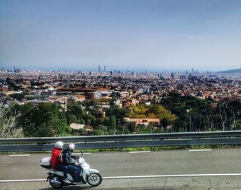 Man riding motorcycle in city against clear sky
