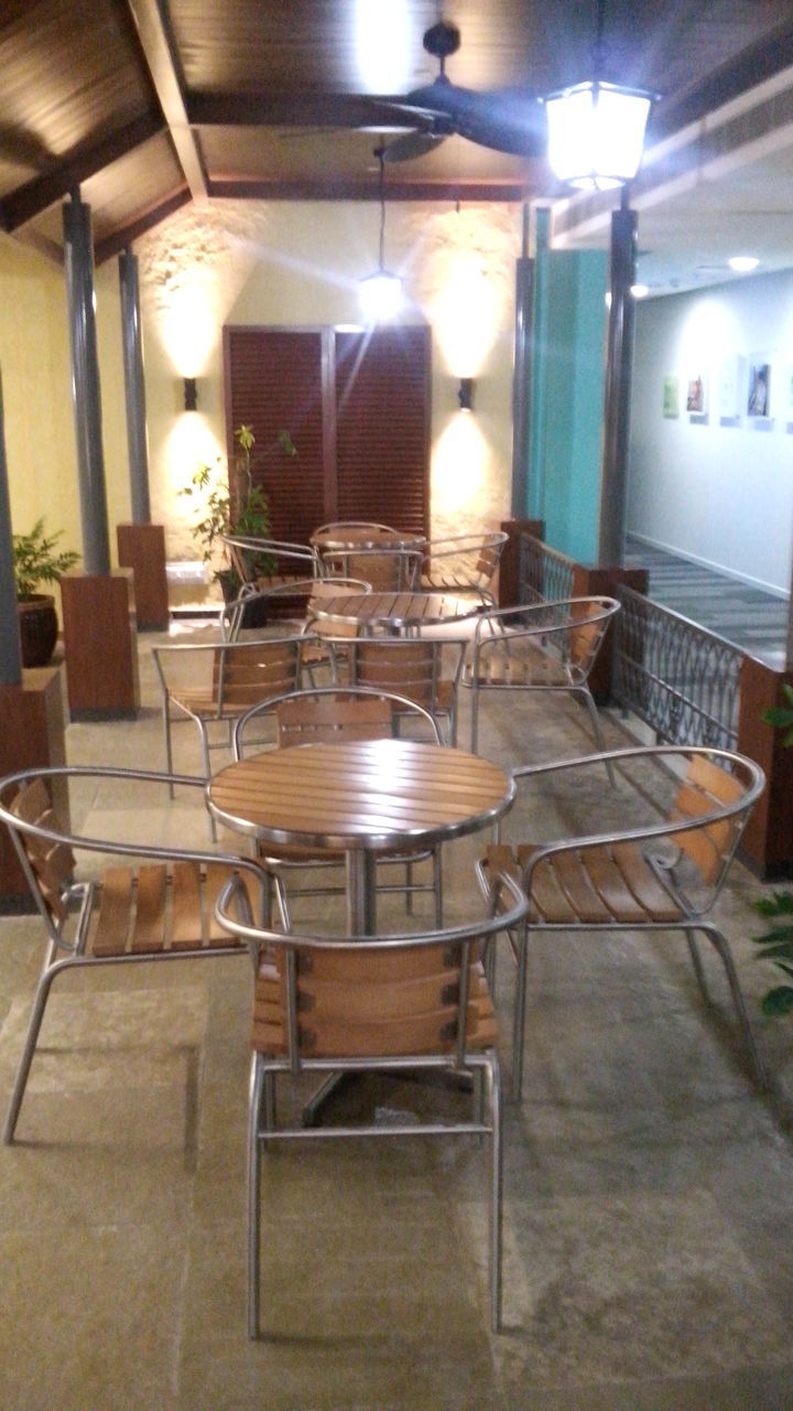 EMPTY TABLE AND CHAIRS IN ILLUMINATED ROOM