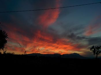 Silhouette of landscape against cloudy sky