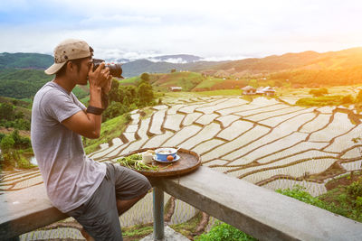 Side view of man photographing on mountain