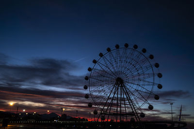 Low angle view of illuminated ferris wheel against sky at night