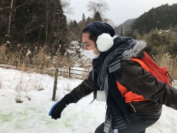 Full length of woman standing on snow covered land