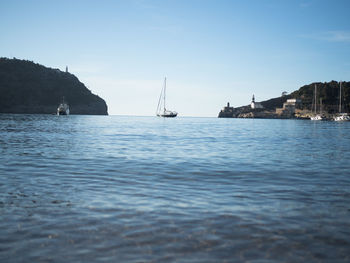 Sailboats sailing in sea against sky